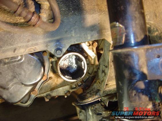Undercarriage of a vehicle showing a detached axle component and surrounding rusty metal parts