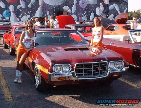 Red 1972 Ford Torino with two women posing, front 3/4 view