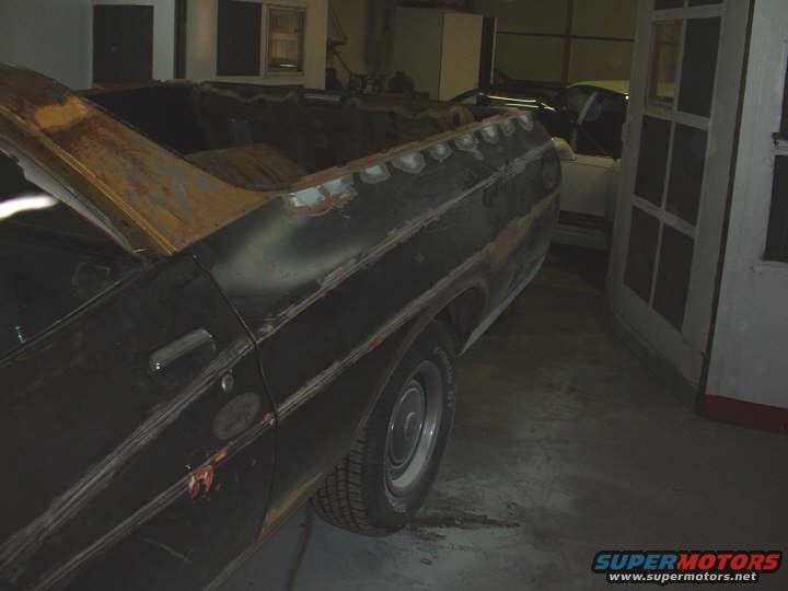 Side view of a rusty pickup truck bed and cab, possibly undergoing restoration