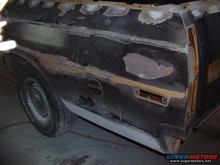 1972 Ford Ranchero side panel with primer and body filler, showing a fuel door and taillight housing