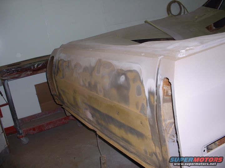 1972 Ford Ranchero side panel with primer and body filler, showing rust and damage