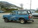 1990 Ford Bronco - A blue 1990 Ford Bronco is parked next to a silver pickup truck.