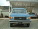 1990 Ford Bronco - Front view of a blue 1990 Ford Bronco parked in a driveway with another vehicle behind it.