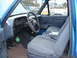 1990 Ford Bronco - The interior of a 1990 Ford Bronco shows grey cloth seats and a dashboard with a prominent steering wheel.