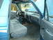1990 Ford Bronco - Interior view of a blue SUV, showing the dashboard, seats, and steering wheel with the hood open.
