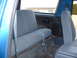 1990 Ford Bronco - Interior view of a blue SUV, showing the rear bench seat and part of the front passenger seat.