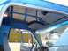 1990 Ford Bronco - Interior view of a blue truck, showing the dashboard and the open passenger door revealing the exterior.