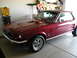 1967 Ford Mustang - Dark red 1967 Ford Mustang coupe parked in a garage with shelves and tools in the background.