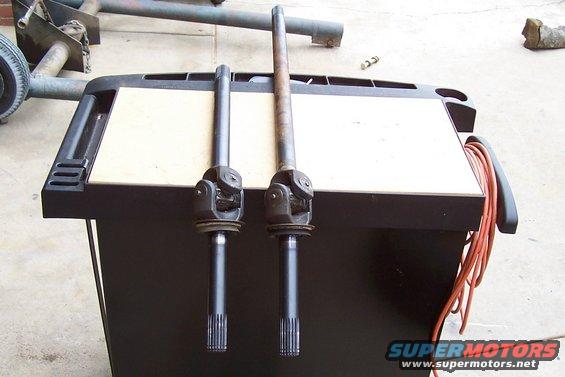 Two CV axle shafts on a workbench