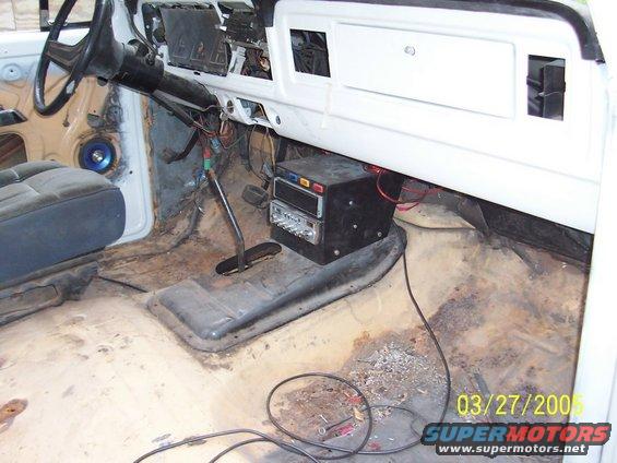 1979 Ford Bronco interior showing a blue seat, dashboard with exposed wires, and a floor-mounted shifter