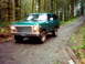 1978 Ford Bronco - This green 1978 Ford Bronco navigates a wet, dirt path through a dense forest.