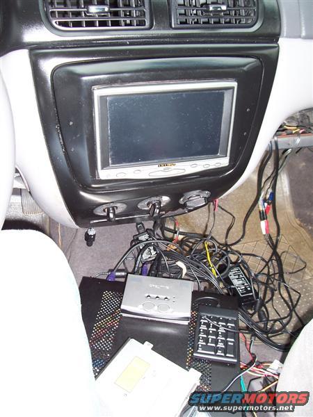 2001 Ford Taurus interior showing a complex aftermarket audio/video system with multiple wires and devices