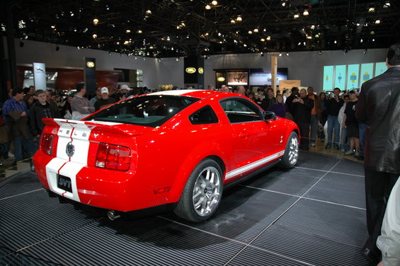 Red 2005 Ford Mustang SVT with white stripes, rear 3/4 view
