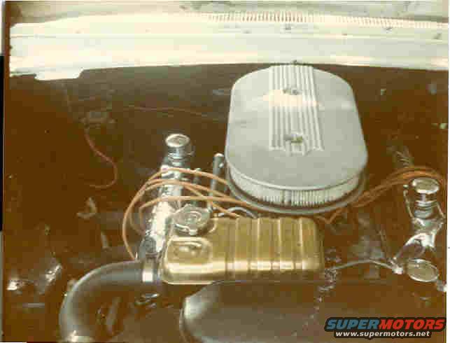 Engine bay showing air cleaner, valve cover, and hoses. Supermotors.net logo visible