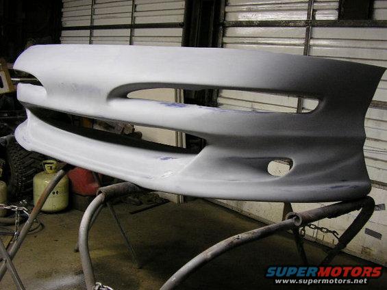 Unpainted front bumper cover on stand