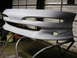1994 Ford Probe - A gray, unpainted front bumper cover is shown mounted on a stand in a workshop.