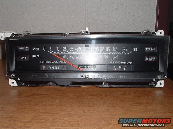 Car dashboard instrument cluster with speedometer, odometer, fuel gauge, and warning lights