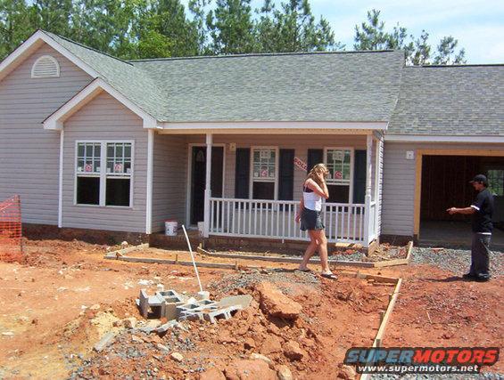 Construction site with a house and two people
