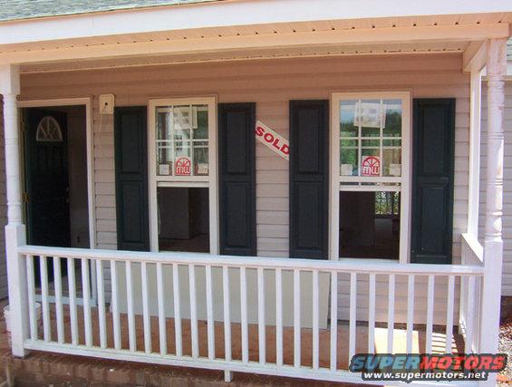 House with a porch, two windows with 'SOLD' signs, and a 'SUPER MOTORS' watermark