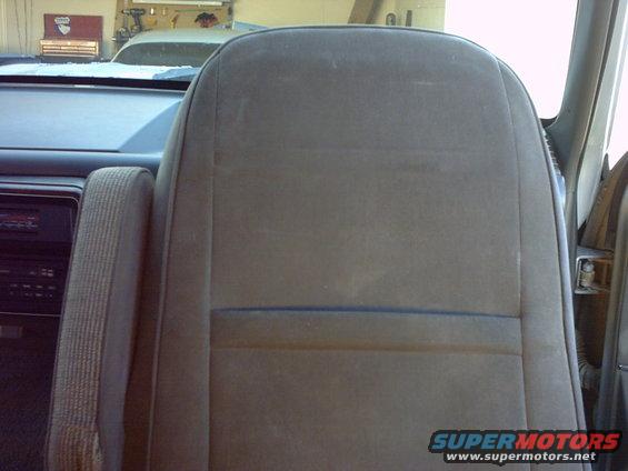 Interior shot of a vehicle's passenger seat and dashboard. A toolbox is visible in the background
