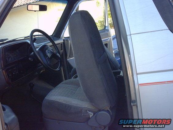 1990 Ford Bronco interior, gray seats, black steering wheel, driver's side door open