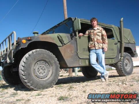 Camouflaged Humvee with a man standing next to it, viewed from the front-left