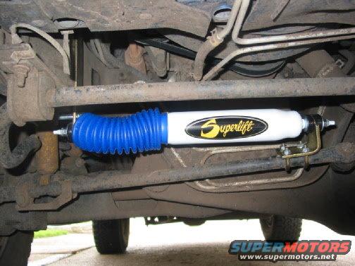 Superlift steering stabilizer with blue boot mounted on vehicle underside