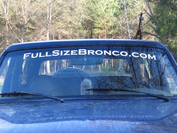 View of a dark blue Ford Bronco's windshield with a white sticker that says "FULLSIZEBRONCO.COM"