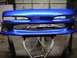 1994 Ford Probe - A freshly painted blue bumper is shown on sawhorses in a garage.