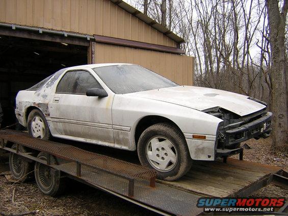 White 1986 Mazda RX-7 on a trailer, front bumper removed