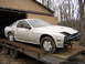 1986 Mazda RX-7 - This white 1986 Mazda RX-7 is seen on a trailer, with its front bumper missing and body in need of repair.
