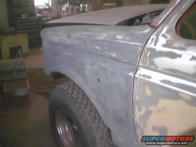 1989 Ford Bronco fender and door in primer, showing bodywork in progress. Supermotors.net logo visible
