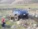1979 Chevrolet C/K Pickup - A blue 1979 Chevrolet C/K Pickup navigates a rocky, off-road terrain with a person filming.
