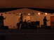 1988 Ford Bronco - A band plays music on a stage under warm lights, with instruments and microphones visible.