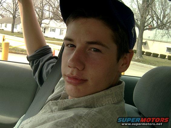 Teenager in car interior, wearing a baseball cap