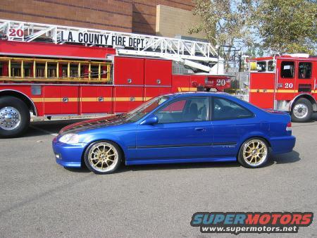 Blue 1999 Honda Civic coupe with gold wheels parked next to a fire truck