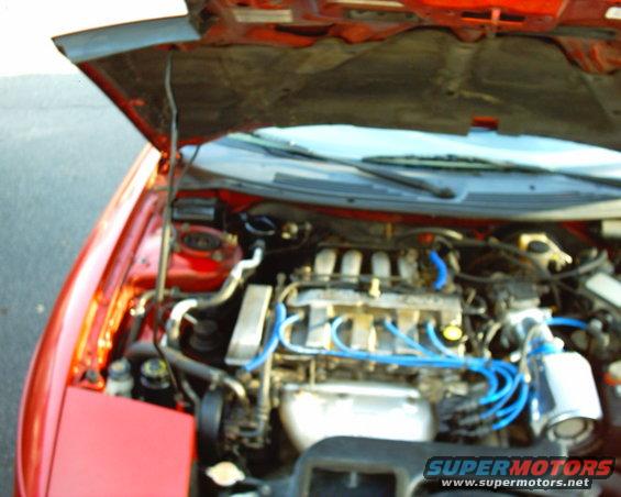 Red 1997 Ford Probe engine bay with hood open, showing V6 engine and blue spark plug wires