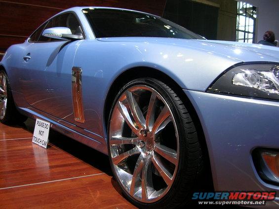 Light blue coupe with chrome wheels and a 'Please Do Not Touch Car' sign on the side