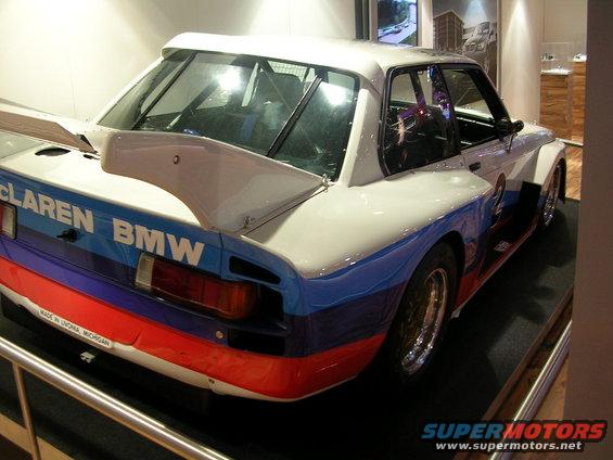 Rear view of a McLaren BMW race car with M stripes on the rear wing and body