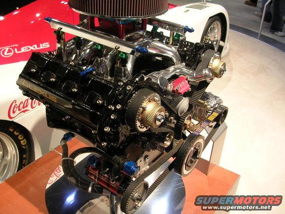 Lexus V8 engine, twin turbos, air intake, and timing belts. Coca-Cola and Lexus logos visible on background