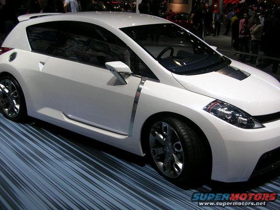 White concept car with chrome accents and a sporty spoiler, viewed from the front three-quarter angle