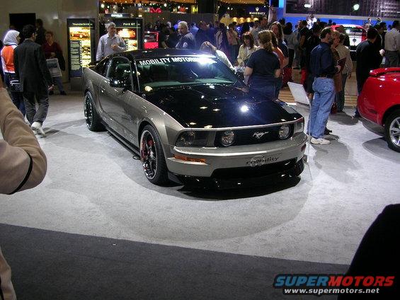 Ford Mustang with a black hood and 'Mobility Motors' on the windshield banner
