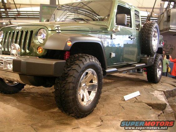 Green Jeep Wrangler with off-road tires and chrome wheels