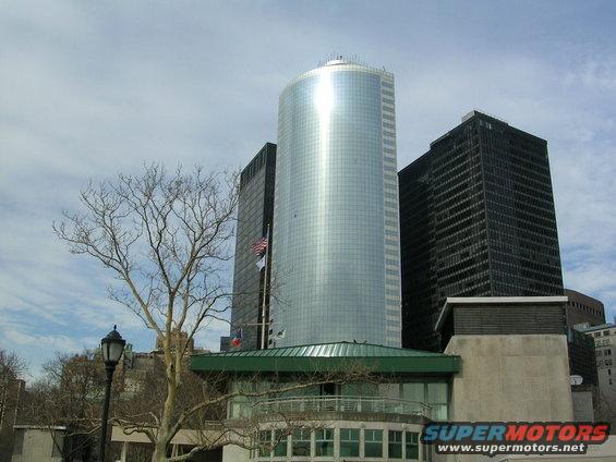 Modern glass and black buildings with a bare tree in the foreground
