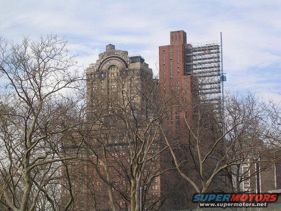 Buildings and bare trees under a cloudy sky