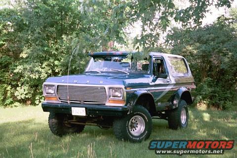 1979 Ford Bronco parked in grassy area with trees behind it