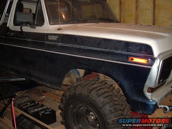 Dark blue and white Bronco, 3/4 front view, large tires