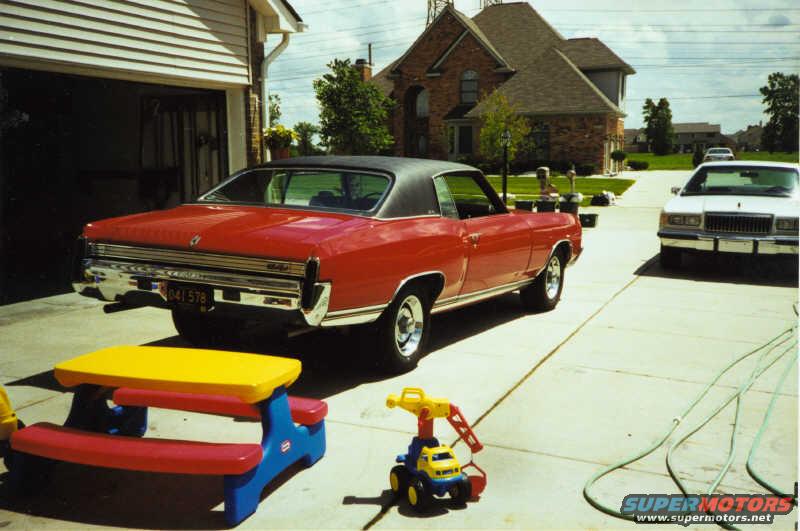 red 1972 Chevrolet Monte Carlo parked in driveway, with a white car behind it