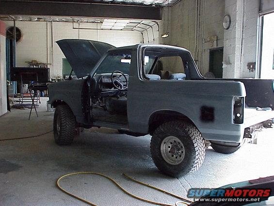 1988 Ford Bronco with hood and doors open, in a garage, undergoing work