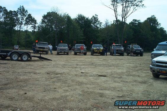 1993 Ford Bronco and other off-road vehicles parked in a dirt lot